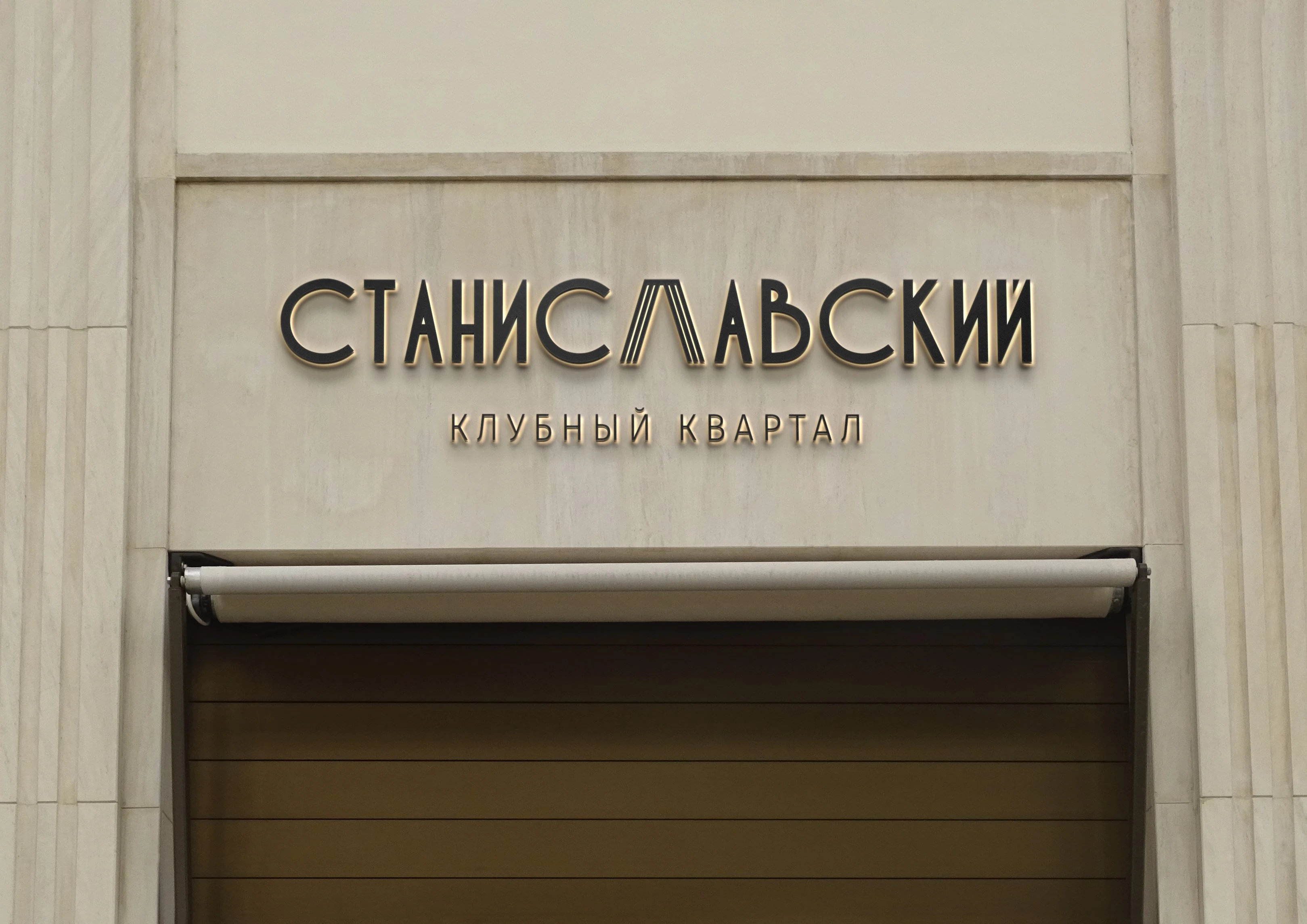 Вывеска клубного квартала «Станиславский» на каменном фасаде